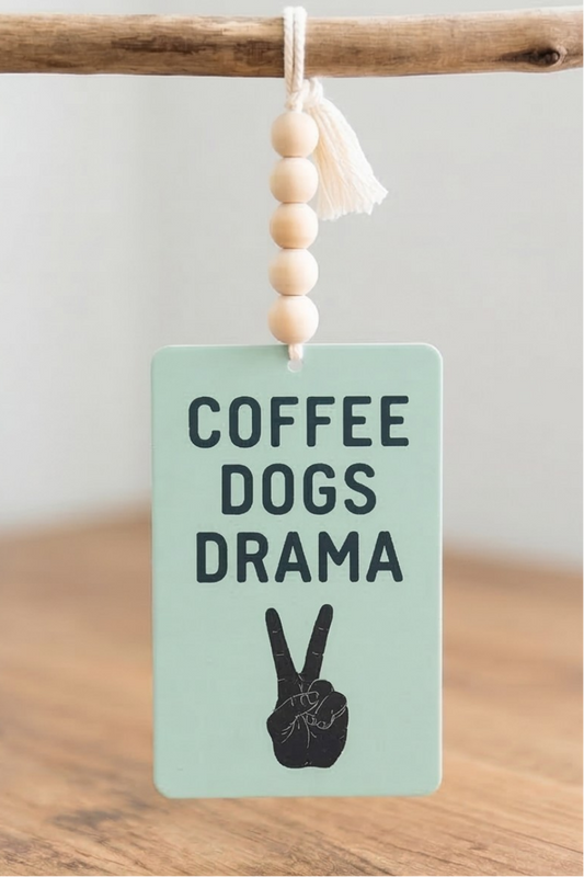 Car Air Freshener with 'Coffee Dogs Drama' text and peace sign on the surface